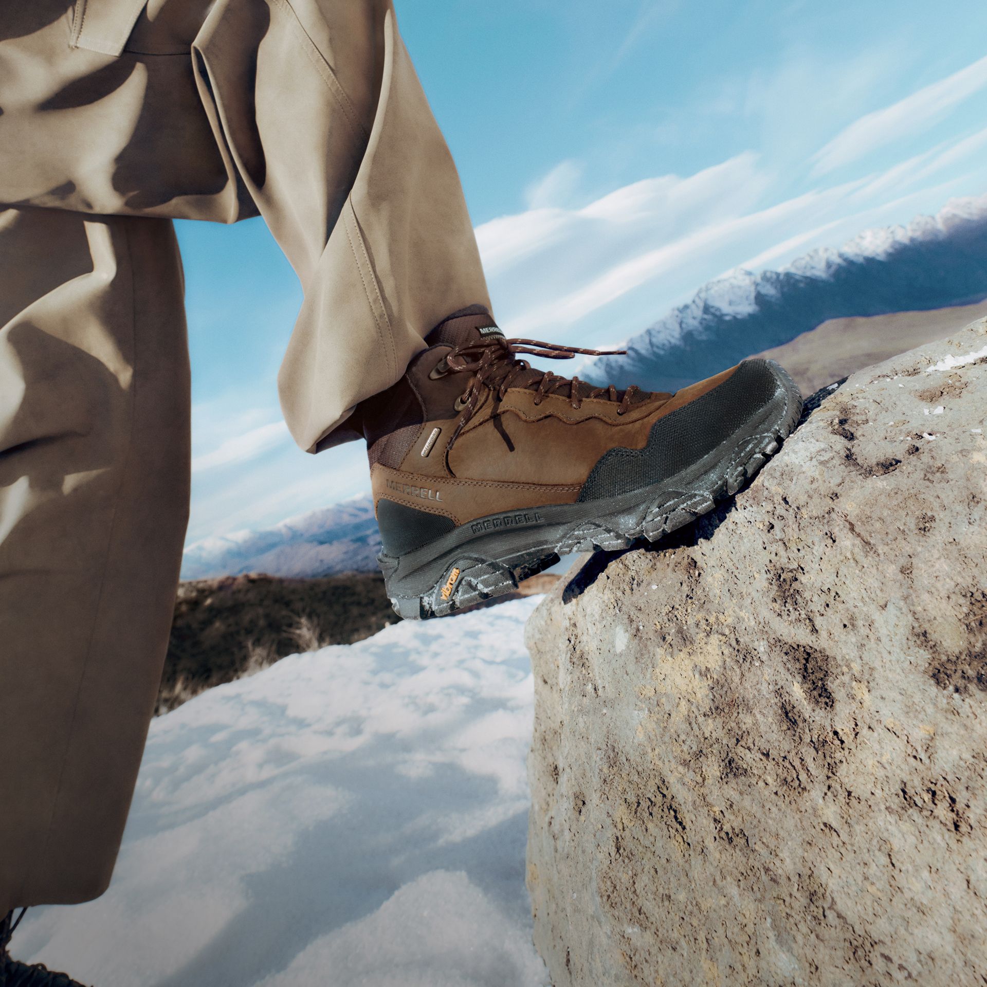 Brown Merrell Coldpack boots on a snowy mountain trail.